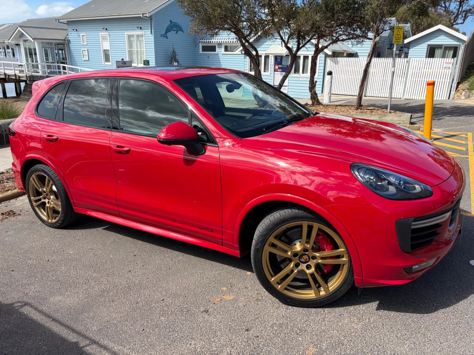 Carmine Red Porsche Cayenne GTS beside the Barwon Heads Bridge